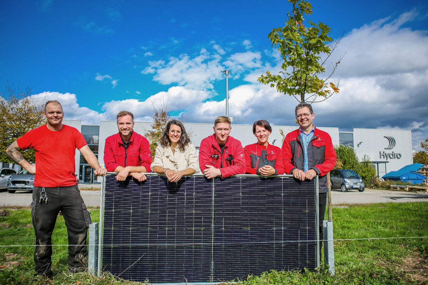 a group of people standing behind a black rectangular object with a black object in front of them