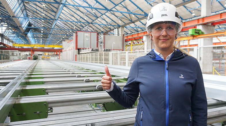 a man wearing a hard hat and holding up a thumb