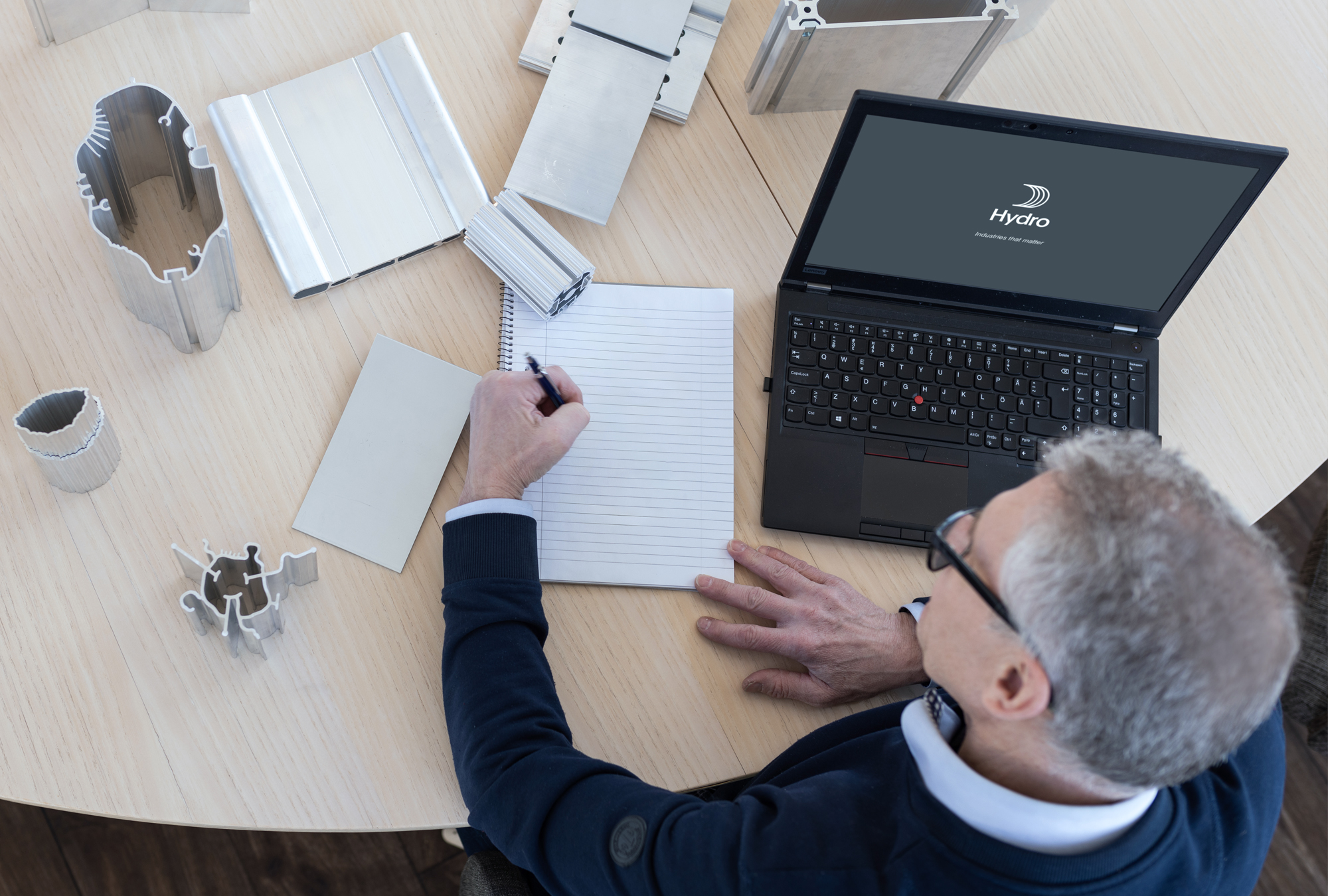 a person sitting at a desk with a laptop and papers